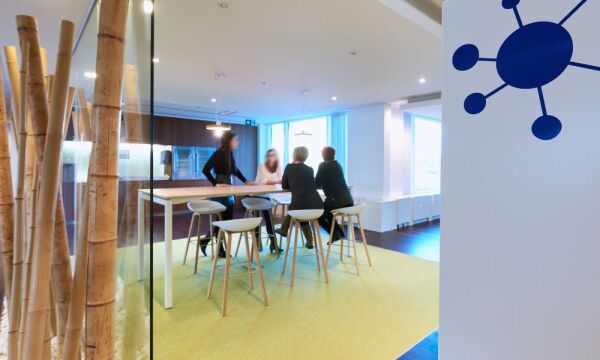 Een eetruimte waarin vier dames aan een statafel zitten op barkrukken